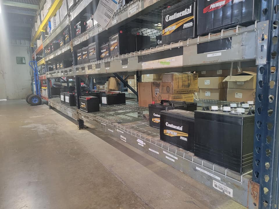 Battery inventory at Holmes Auto Supply Decatur TX — Continental Supreme batteries on warehouse shelving